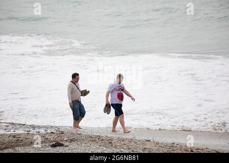 Portreath,Cornwall,7. Juli 2021,Trotz des grauen und trostlosen Wetters waren einige Leute bei Flut am Strand in Portreath, Cornwall. Surfer machten das Beste aus den großen Wellen, da das Wetter voraussichtlich 17C sonnige Intervalle mit einer leichten Brise später an diesem Abend sein wird.Quelle: Keith Larby/Alamy Live News Stockfoto