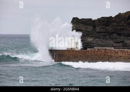 Portreath,Cornwall,7. Juli 2021,Trotz des grauen und trostlosen Wetters waren einige Leute bei Flut am Strand in Portreath, Cornwall. Surfer machten das Beste aus den großen Wellen, da das Wetter voraussichtlich 17C sonnige Intervalle mit einer leichten Brise später an diesem Abend sein wird.Quelle: Keith Larby/Alamy Live News Stockfoto