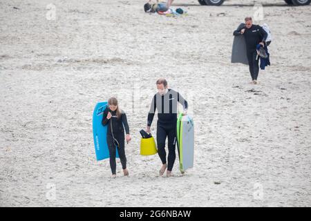 Portreath,Cornwall,7. Juli 2021,Trotz des grauen und trostlosen Wetters waren einige Leute bei Flut am Strand in Portreath, Cornwall. Surfer machten das Beste aus den großen Wellen, da das Wetter voraussichtlich 17C sonnige Intervalle mit einer leichten Brise später an diesem Abend sein wird.Quelle: Keith Larby/Alamy Live News Stockfoto