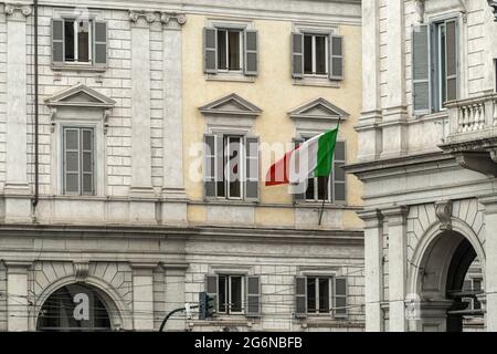 Zwischen den Palästen der Piazza dei Cinquecento in Rom flattert die italienische Flagge. Rom, Latium, Italien, Europa Stockfoto