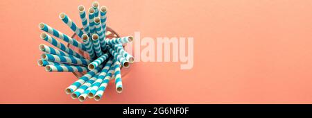 Trinkhalm. Farbige Cocktailröhrchen aus Papier auf einem rosa Hintergrund. In einer Glasschale. Blick von oben, Nahaufnahme. Platz für Text Stockfoto