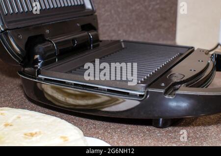 Elektrischer Grill auf dem Hintergrund der Küche. Nahaufnahme, Toaster. Stockfoto