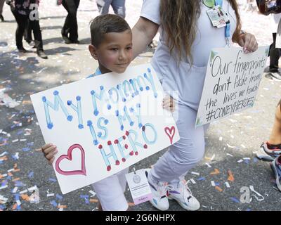 Ein Junge hält ein Schild, während er die Paraderoute bei der Ticker-Parade „Hometown Heroes“ zur Feier des „Summer of New York City“ begeht und sich bei wichtigen Mitarbeitern bedankt, die den New Yorkern bei der schlimmsten Pandemie des Coronavirus (COVID-19) im Canyon of Heroes in New York City geholfen haben Am Mittwoch, den 7. Juli 2021. Die Parade umfasst eine Vielzahl verschiedener Festwagen, die jeweils eine Gruppe wichtiger Arbeiter repräsentieren, die der Stadt dienten, darunter: Stadtarbeiter, Erzieher, Lebensmittelversorger, Glaubensführer, Ersthelfer, Mitarbeiter im Gesundheitswesen, im Gastgewerbe und in Gebäuden, im Einzelhandel und in der Bodega Stockfoto