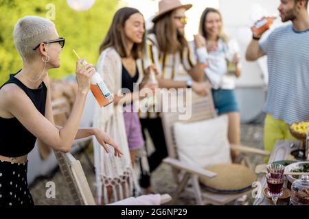 Junge, stilvolle Freunde bei einem festlichen Abendessen auf der Dachterrasse Stockfoto
