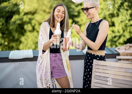 Junge, stilvolle Freunde bei einem festlichen Abendessen auf der Dachterrasse Stockfoto