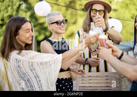 Junge, stilvolle Freunde bei einem festlichen Abendessen auf der Dachterrasse Stockfoto