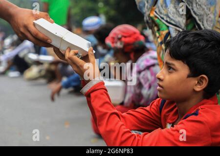 Dhaka, Bangladesch. Juli 2021. Die armen Menschen haben während der landesweiten Sperre von Studenten der Dhaka University die Lebensmittelverteilung beobachtet. (Foto von MD Manik/SOPA Images/Sipa USA) Quelle: SIPA USA/Alamy Live News Stockfoto