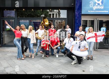 London, Großbritannien. Juli 2021. Atomic Kitten und die Blaskapelle Hyde Park Brass und die Gastgeber von Capital Breakfast, Roman Kemp, Sonny Jay und Sian Welby, stimmen sich mit einer ‘Whole Again'-Version mit dem Titel ‘Southgate You're The One auf das englische Eurosemi-Finale ein (Football's Coming Home Again)“ vor den Radiostudios von Capital auf dem Londoner Leicester Square. (Foto von Brett Cove/SOPA Images/Sipa USA) Quelle: SIPA USA/Alamy Live News Stockfoto