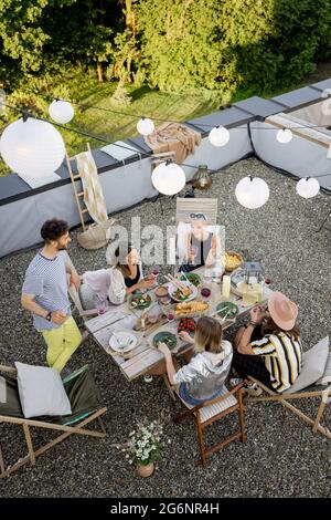 Freunde genießen ein festliches Abendessen auf der Dachterrasse Stockfoto