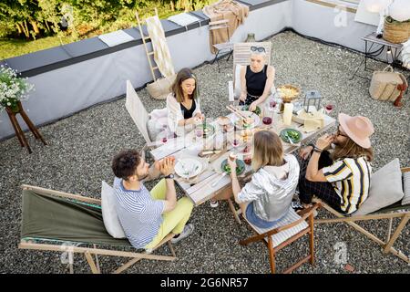 Freunde genießen ein festliches Abendessen auf der Dachterrasse Stockfoto