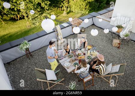 Freunde genießen ein festliches Abendessen auf der Dachterrasse Stockfoto