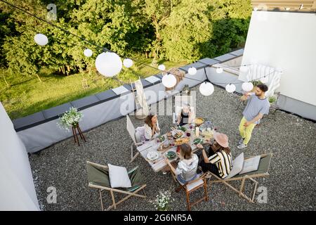 Freunde genießen ein festliches Abendessen auf der Dachterrasse Stockfoto