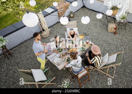 Freunde genießen ein festliches Abendessen auf der Dachterrasse Stockfoto