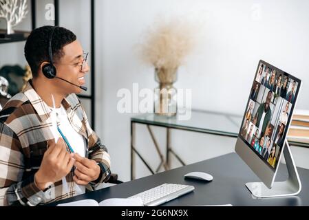 Videokommunikation aus der Ferne. Der junge Mann, Mitarbeiter oder ceo von Latino kommuniziert per Videokonferenz mit dem Geschäftsteam, diskutiert ein Projekt, analysiert einen Geschäftsplan und führt ein Online-Brainstorming durch Stockfoto