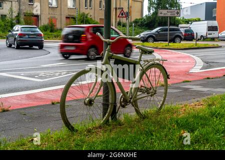 Weißes Fahrrad erinnert an einen tödlichen Unfall mit einem Radfahrer, rote Radweg markiert in einem innerstädtischen Kreisverkehr, um Fahrer darauf aufmerksam zu machen, dass auch Radfahrer Stockfoto