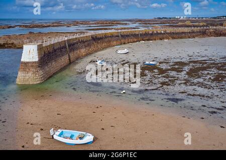 Bild des Hafens von La Rocque bei Ebbe mit blauem Himmel und befahrten Booten und Hafenpier, Jerey, Kanalinseln, St. Clement. Stockfoto