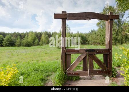 Hölzerne geschlossene Tore zur Wiese, der Durchgang ist geschlossen Stockfoto