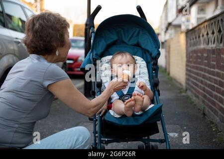 Ein Baby wird mit einem Eis gefüttert Stockfoto