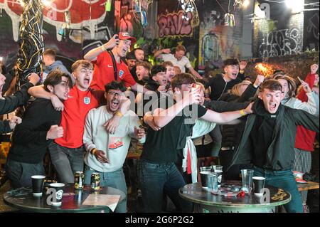 Digbeth, Birmingham, Großbritannien 7. Juli 2021 Fans feiern ein Tor gegen Dänemark in der Verlängerung des Halbfinals der Euro 2020. Die Fans brachen aus, als sie die Big Fang Popup Bar unter Eisenbahnbögen im Stadtzentrum von Birmingham beobachteten. PIC by Credit: Stop Press Media/Alamy Live News Stockfoto