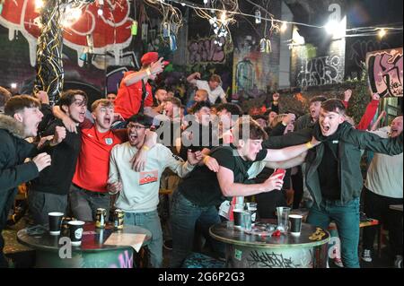 Digbeth, Birmingham, Großbritannien 7. Juli 2021 Fans feiern ein Tor gegen Dänemark in der Verlängerung des Halbfinals der Euro 2020. Die Fans brachen aus, als sie die Big Fang Popup Bar unter Eisenbahnbögen im Stadtzentrum von Birmingham beobachteten. PIC by Credit: Stop Press Media/Alamy Live News Stockfoto