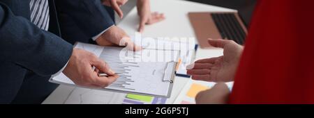 Gruppe von Personen, die das Diagramm in Dokumenten in der Nahaufnahme des Büros diskutieren Stockfoto