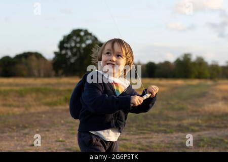 Ein Porträt eines Jungen, der einen Drachen fliegt Stockfoto