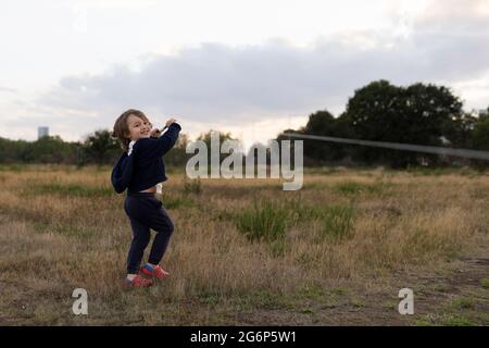 Ein Porträt eines Jungen, der einen Drachen fliegt Stockfoto