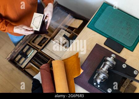 Draufsicht Handwerker Hände Wahl Lockenmesser oder Stanzen zum Schneiden Form arbeiten mit natürlichen Sachen Stockfoto