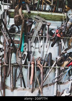 Viele alte und rostige Handwerkzeuge. Detail des Arbeitsplatdes Mechanikers in der Garage. Toolkit für Reparaturwerkstätten Stockfoto