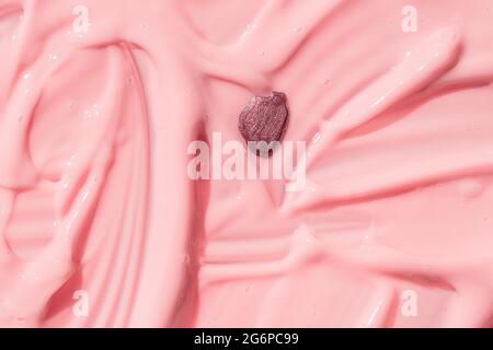 Abstrakt kosmetisch strukturierter Hintergrund, Nagellack Tropfen auf flüssige Foundation Textur. Feuchtigkeitsspendende Schönheitscreme, Balsam, rosa Farbe, Joghurt Stockfoto