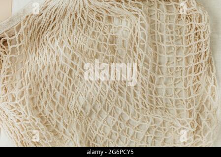 Wiederverwendbare, beigefarbene Baumwoll-Mesh-Taschen auf beigem Hintergrund. Umweltfreundliche Einkaufstasche. Nahaufnahme. Zero Waste Lebensmittelkonzept. Nachhaltig Stockfoto
