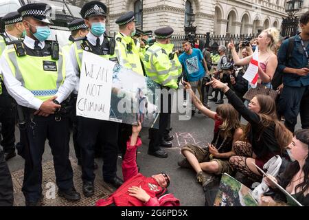 Während der Demonstration vor der Downing Street rufen Roma-Demonstranten Polizisten an.Drive2Survive ist eine Kampagne gegen die Sektion 4 des Polizeigesetzes, die Zigeuner, Roma, irische Reisende und Nomadenleben in Großbritannien bedroht. Gegen das Polizeigesetz wurde protestiert, weil es das nomadische Leben im Vereinigten Königreich bedroht und der Polizei die Macht gibt, Zigeuner-, Roma- und irische Wohnheime zu beschlagnahmen und die Gemeinschaft hohen Geldstrafen zu unterwerfen. Die Kundgebung begann am Parliament Square, ging dem Europahaus voraus und ging zurück in die Downing Street, wo einige Demonstranten verhaftet wurden. Stockfoto