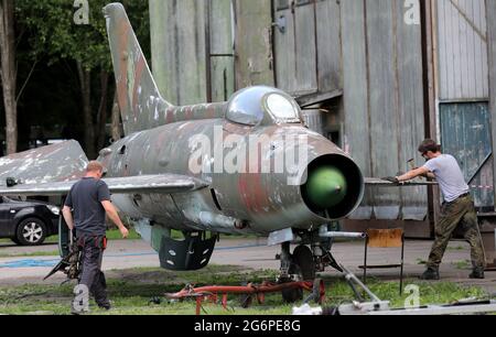 06. Juli 2021, Mecklenburg-Vorpommern, Ribnitz-Damgarten: Im Technik-Museum Pütnitz arbeiten Vereinsmitglieder an einem ehemaligen russischen Kampfflugzeug vom Typ MiG-21. Das Museum befindet sich auf einem ehemaligen Militärflugplatz, der 1935 erbaut wurde und bis 1994 von russischen Truppen genutzt wurde. In drei Messehallen - ehemaligen Flugzeughangars - wird "Technologie des ehemaligen Ostblocks" präsentiert, im Freigelände kann man unter anderem mit Militärfahrzeugen und Bussen an Fahraktionen teilnehmen. Der Verein der Freunde und Förderer des Technischen Museums erhält ein Stipendium von Stockfoto