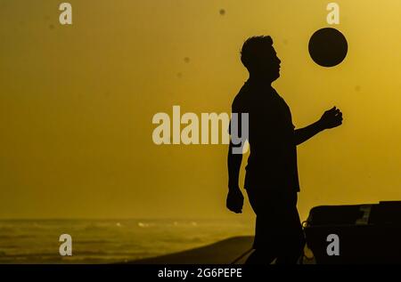 San Salvador, El Salvador. Juli 2021. Ein Mann spielt am Strand von San Marcelino bei Sonnenuntergang Fußball. (Foto von Camilo Freedman/SOPA Images/Sipa USA) Quelle: SIPA USA/Alamy Live News Stockfoto