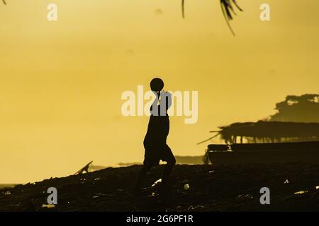 San Salvador, El Salvador. Juli 2021. Ein Mann spielt am Strand von San Marcelino bei Sonnenuntergang Fußball. Kredit: SOPA Images Limited/Alamy Live Nachrichten Stockfoto