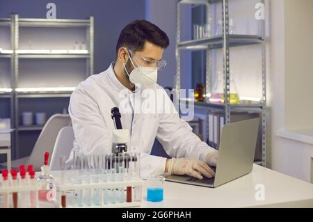 Medizinwissenschaftler, der an einem Laptop arbeitet, während er in einem Wissenschaftslabor forscht Stockfoto