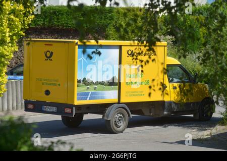 Leipziger Land, Deutschland. Juni 2021. Ein Lieferwagen der Deutschen Post mit der grünen Aufschrift „natürlich natürlich. Das Fahrzeug läuft mit Strom' steht in einem Dorf in der Leipziger Landschaft, eingerahmt von grünen Büschen und Bäumen. Quelle: Volkmar Heinz/dpa-Zentralbild/ZB/dpa/Alamy Live News Stockfoto