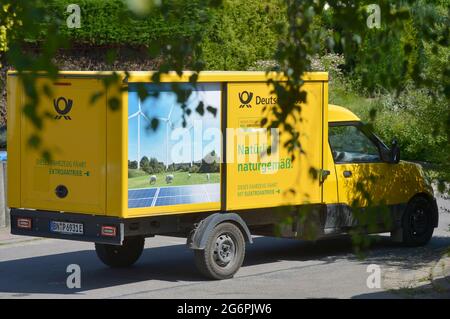 Leipziger Land, Deutschland. Juni 2021. Ein Lieferwagen der Deutschen Post mit der grünen Aufschrift „natürlich natürlich. Das Fahrzeug läuft mit Strom' steht in einem Dorf in der Leipziger Landschaft, eingerahmt von grünen Büschen und Bäumen. Quelle: Volkmar Heinz/dpa-Zentralbild/ZB/dpa/Alamy Live News Stockfoto