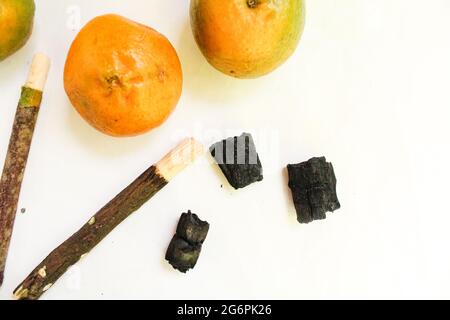 Miswak-Stick mit Orange auf weißer Oberfläche, Miswak für bessere Zähne und muslime Stockfoto