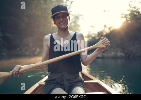 Lächelnde Frau genießt das Kanufahren Stockfoto