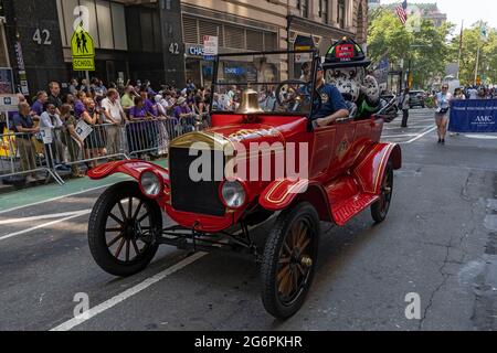 NEW YORK, NY - 07. JULI: Während der Ticker Tape Parade der „Hometown Heroes“ am 07. Juli 2021 in New York City fährt ein Hundefeuerwehr mit einem alten FDNY-Auto. Im Canyon of Heroes in Manhattan werden Mitarbeiter des Gesundheitswesens, Ersthelfer und wichtige Mitarbeiter für ihren Dienst während der Covid-19-Pandemie geehrt. Stockfoto