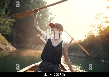 Frau genießen Kanufahrt auf einem See Stockfoto