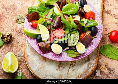 Diätsalat aus Mangold, Wachteleiern, Tomaten und Ruckeys. Salat mit Jamon und Gemüse. Stockfoto