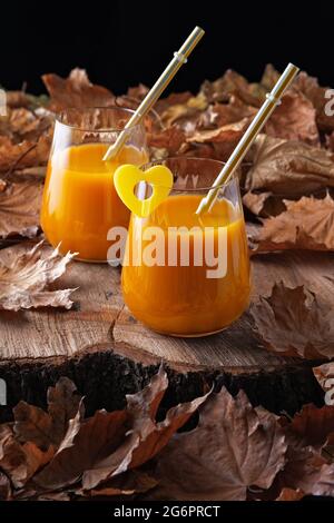 Stillleben im Herbst mit Pfirsichsaft und abgefallenen Blättern Stockfoto