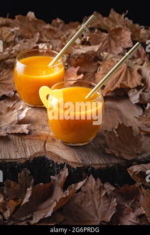 Stillleben im Herbst mit Pfirsichsaft und abgefallenen Blättern Stockfoto