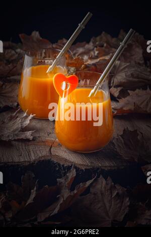 Stillleben im Herbst mit Pfirsichsaft und abgefallenen Blättern Stockfoto