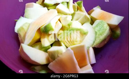 Rohe Mango in Scheiben geschnitten in einer roten Schüssel zur Vorbereitung von Launji (chatni) Stockfoto