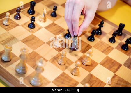 Wardenburg, Deutschland. Juli 2021. Ein Spieler legt ein hölzernes Schachstück auf ein Schachbrett. Chess ist ein strategisches Brettspiel, bei dem zwei Spieler abwechselnd Schachfiguren auf einem Schachbrett bewegen. Das Ziel des Spiels ist es, den Gegner zu kaschieren, das heißt, seinen König so anzugreifen, dass er weder verteidigen noch entkommen kann. Quelle: Hauke-Christian Dittrich/dpa/Alamy Live News Stockfoto