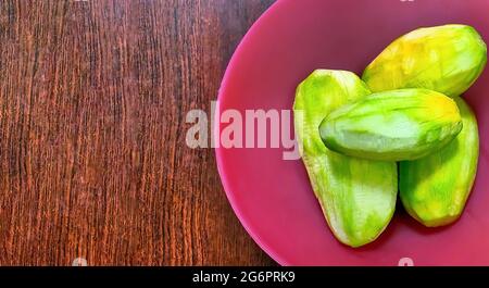 Tropische Früchte grüne Mango (Kachha aam) auf Holztisch Stockfoto