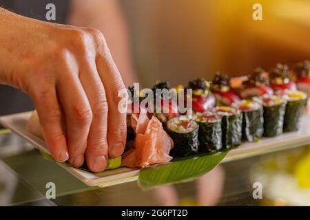 Der Küchenchef dekoriert Sushi-Brötchen für das Servieren im Restaurant. Stockfoto